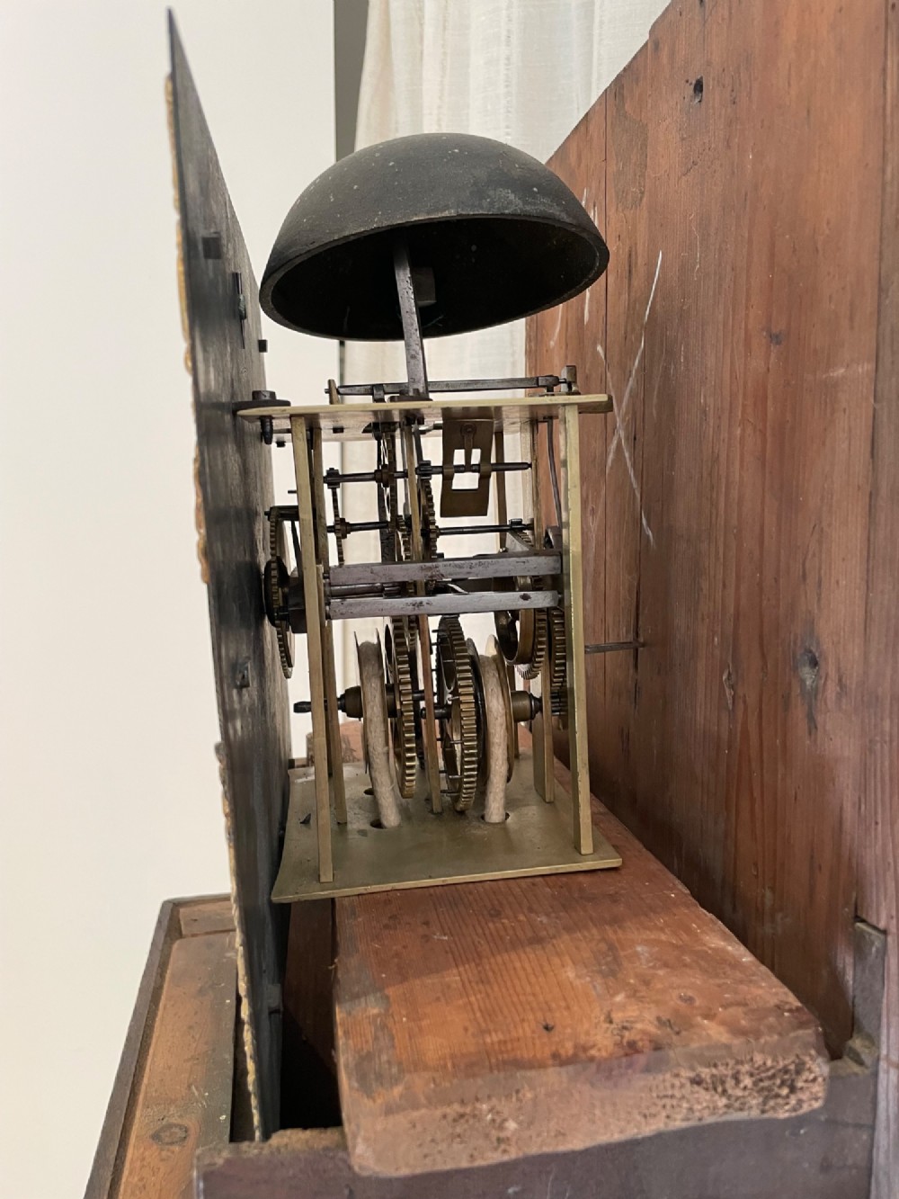 An antique Georgian oak longcase clock featuring a square glass hood door, a brass dial with Roman numerals, and a slim trunk with a hinged door. View III