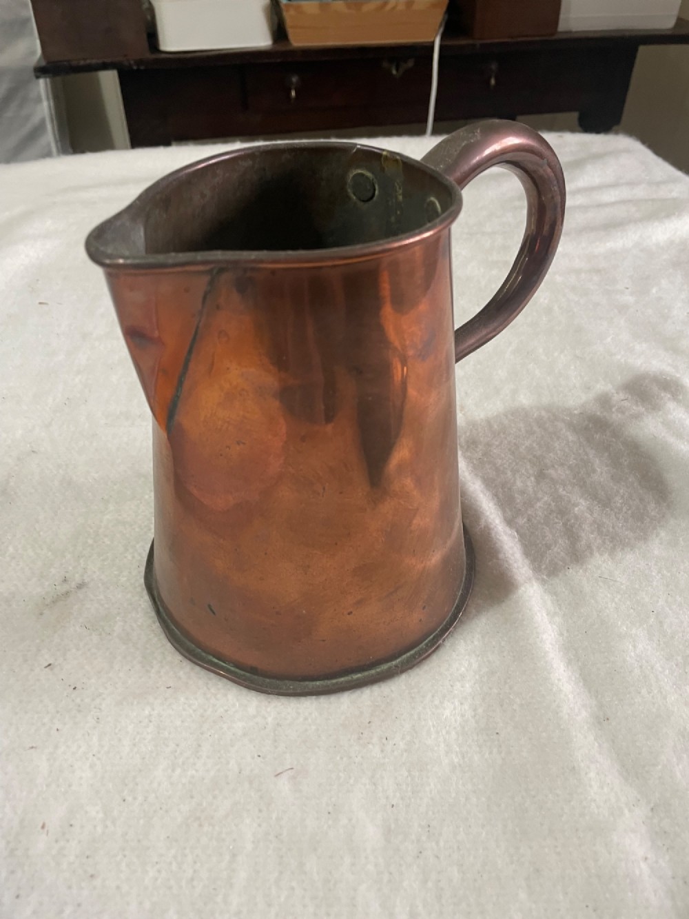 A Victorian copper jug featuring a tapered cylindrical body, a distinct pouring spout, and a thick riveted loop handle. View II
