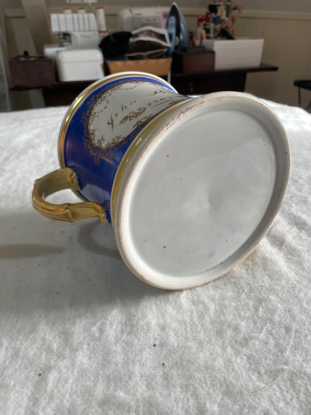 A cobalt blue porcelain two-handled loving cup featuring a hand-painted floral bouquet within a gilded ornate frame. View III