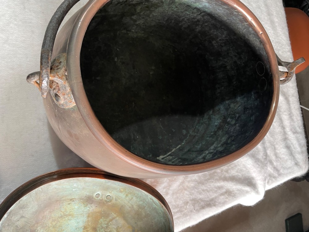 A large antique copper pot featuring a fitted lid with a copper handle and an arched iron swing handle. View IV