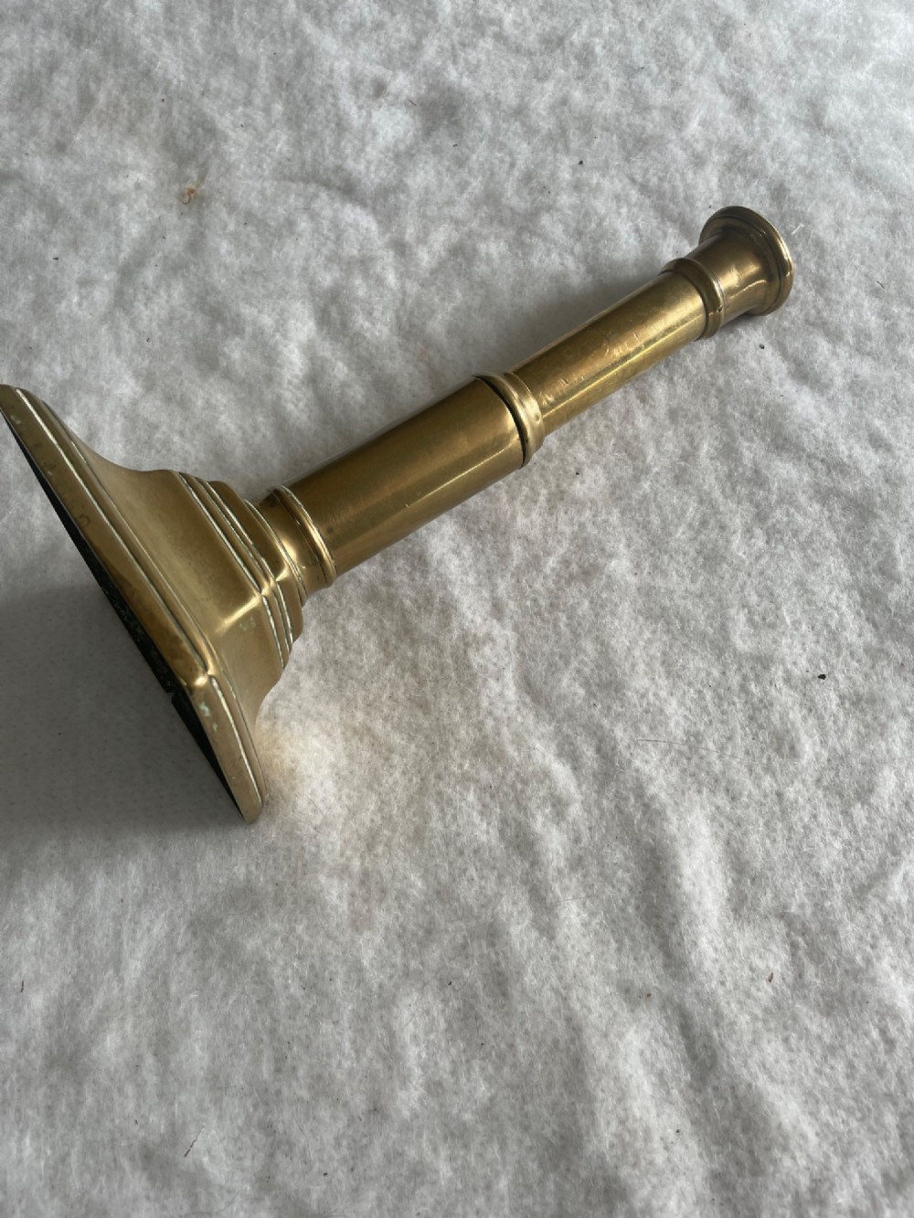 A group of eight early brass candlesticks displaying varied heights with square, round, and scalloped bases paired with turned and fluted stems. View III