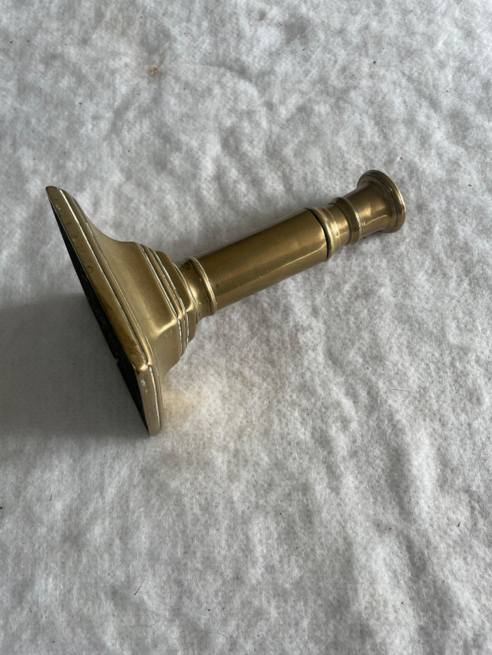 A group of eight early brass candlesticks displaying varied heights with square, round, and scalloped bases paired with turned and fluted stems. View IV
