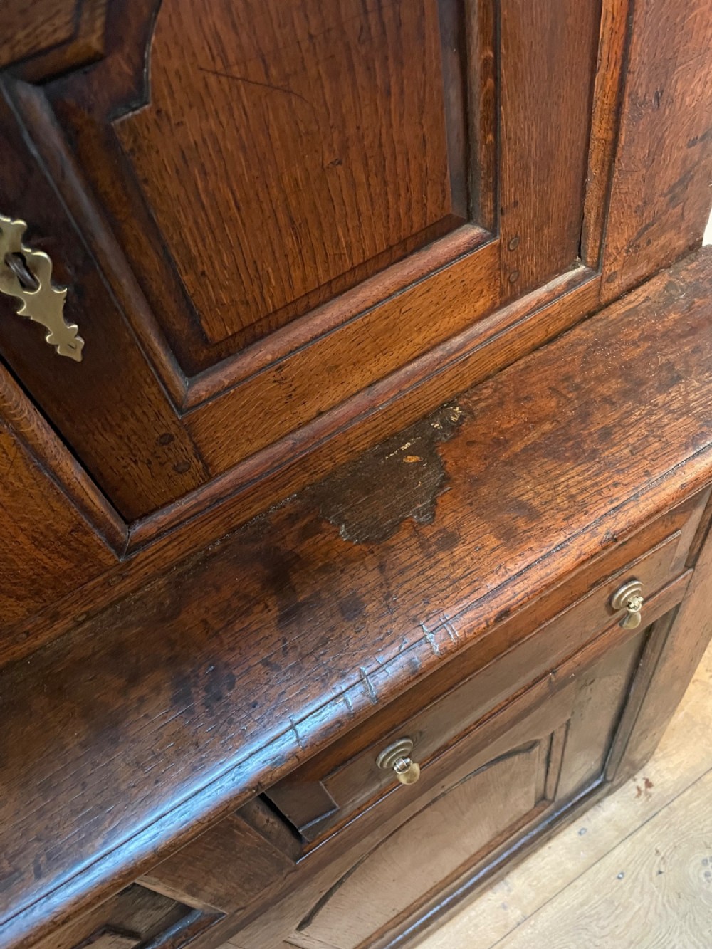 A dark oak three-tier Welsh tridarn featuring an open upper shelf with turned columns above a double-cupboard section and a lower base with drawers and doors. View V