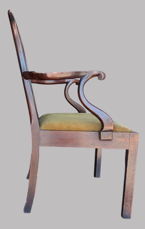 A Georgian mahogany elbow chair featuring a carved pierced back splat, curved arms, and an olive green fabric seat cushion on square legs. View V