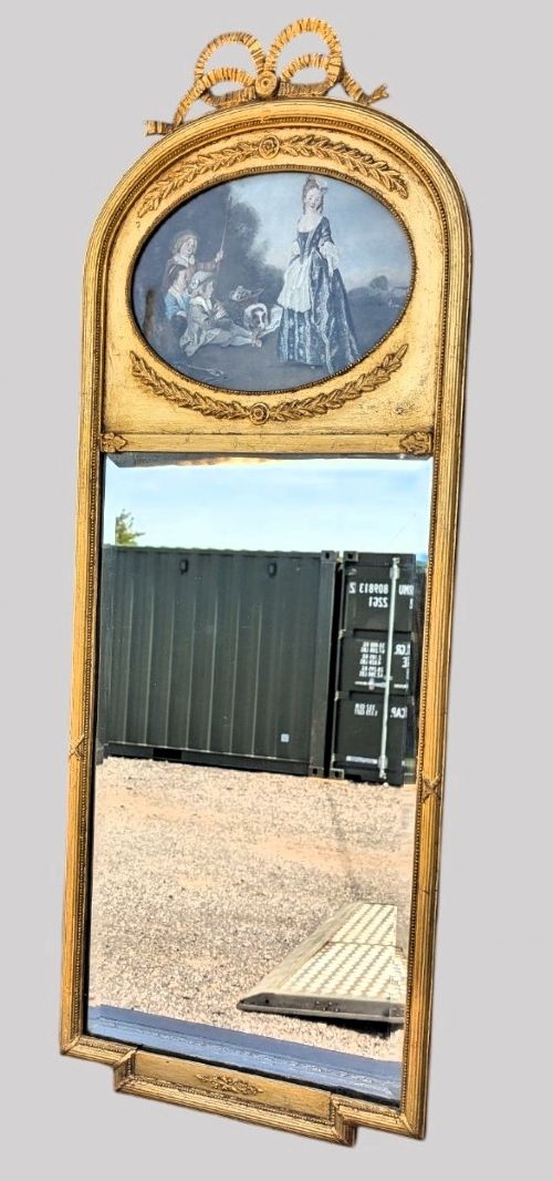 An arched giltwood pier mirror featuring a ribbon bow crest and an upper oval painted scene framed by laurel wreaths above a glass plate. View III