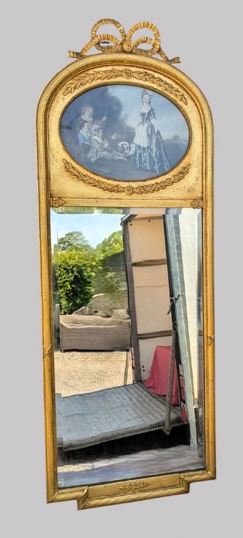 An arched giltwood pier mirror featuring a ribbon bow crest and an upper oval painted scene framed by laurel wreaths above a glass plate. View IV