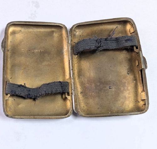 An open antique sterling silver cigarette case featuring hand-engraved foliate scrollwork and a blank shield cartouche on the outer cover. View II