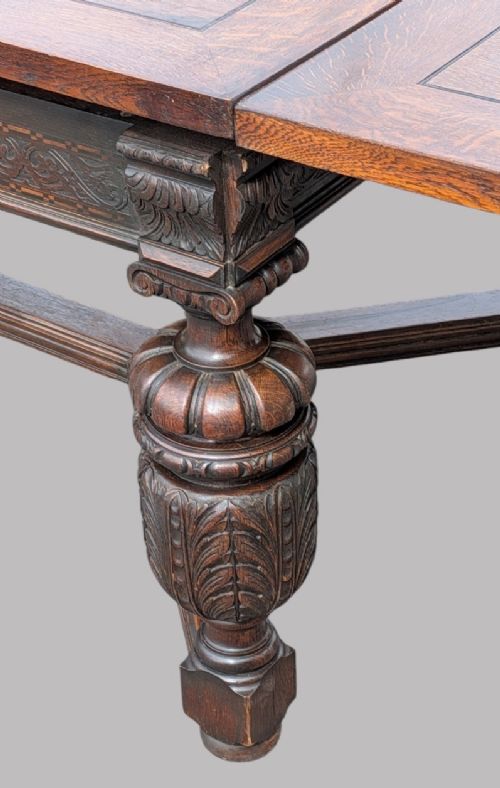 fig 1. A rectangular extending oak dining table showing a quarter-sawn timber surface and carved bulbous legs underneath.