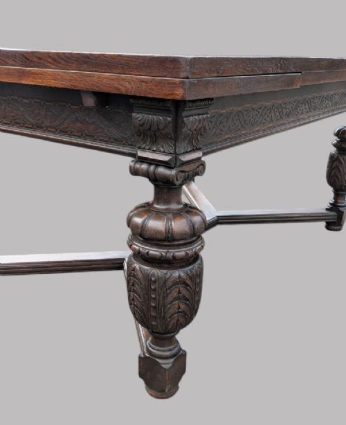 fig 2. A rectangular extending oak dining table showing a quarter-sawn timber surface and carved bulbous legs underneath.