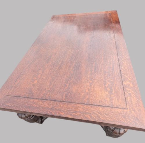 fig 2. A rectangular extending oak dining table showing a quarter-sawn timber surface and carved bulbous legs underneath.