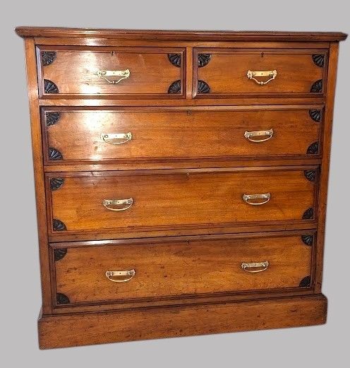 fig 1. A Victorian mahogany chest of drawers featuring two short drawers over three long drawers with brass drop handles and carved spandrel details on a plinth base.