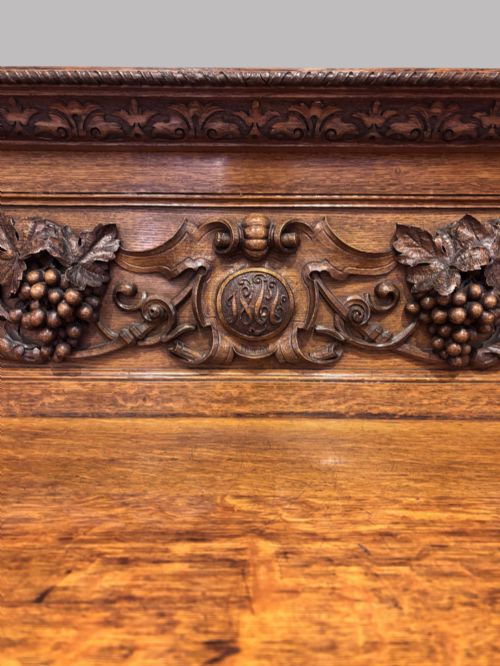fig 1. A carved dark oak Victorian sideboard featuring a raised back gallery, relief fruit carvings, barley twist columns, and two pedestal cupboards flanking an open centre.