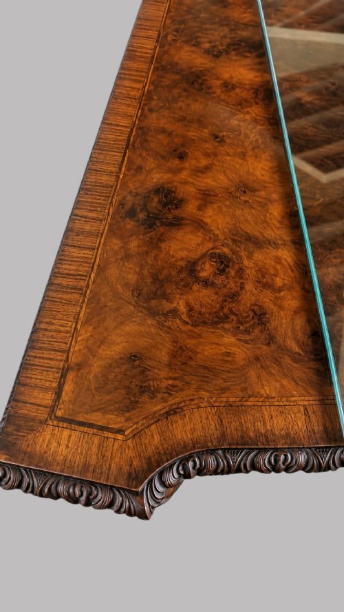fig 1. A bow-front burr walnut sideboard with carved pilasters, twin cupboard doors, a top drawer, and four carved cabriole legs ending in ball and claw feet.