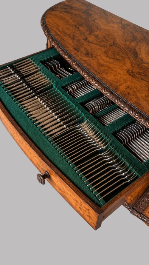 A bow-front burr walnut sideboard with carved pilasters, twin cupboard doors, a top drawer, and four carved cabriole legs ending in ball and claw feet. View VIII