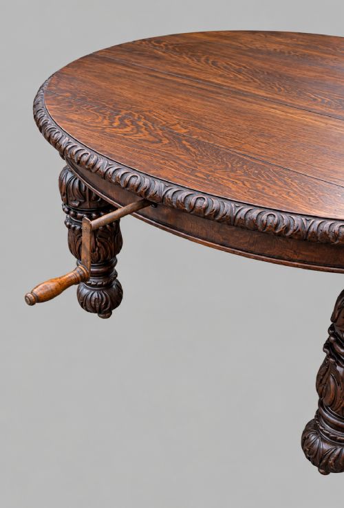 fig 1. A late 19th-century oak extending dining table featuring a quarter-sawn wood top, carved apron moulding, and turned legs.
