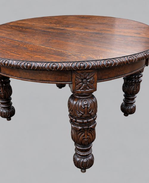 fig 2. A late 19th-century oak extending dining table featuring a quarter-sawn wood top, carved apron moulding, and turned legs.