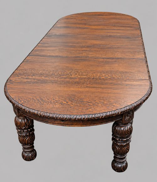 fig 4. A late 19th-century oak extending dining table featuring a quarter-sawn wood top, carved apron moulding, and turned legs.