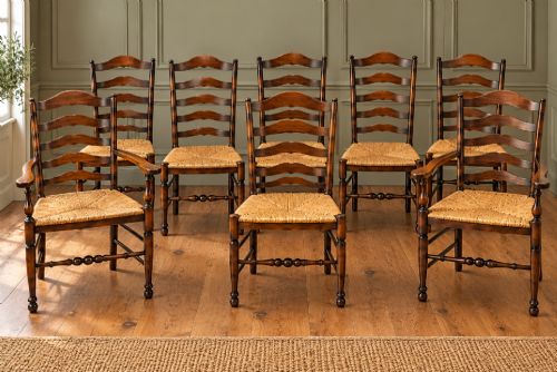 fig 1. A set of eight dark wood ladderback dining chairs with hand-woven rush seats, including two armchairs and six side chairs.