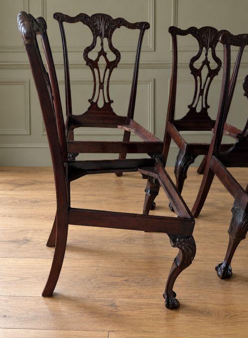 fig 2. A set of four mahogany Chippendale style dining chairs featuring carved pierced splats, gold-coloured velvet seats, and cabriole front legs with ball-and-claw feet.