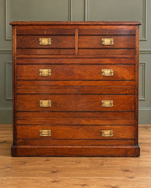 fig 2. A Victorian warm brown walnut chest of drawers featuring a two-over-three drawer arrangement, reeded moulding, and fitted brass handles.