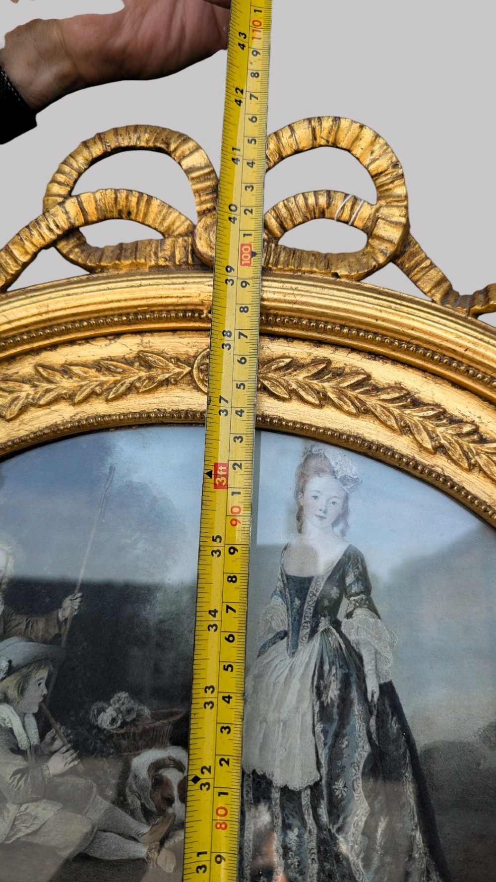 An arched giltwood pier mirror featuring a ribbon bow crest and an upper oval painted scene framed by laurel wreaths above a glass plate. View VIII