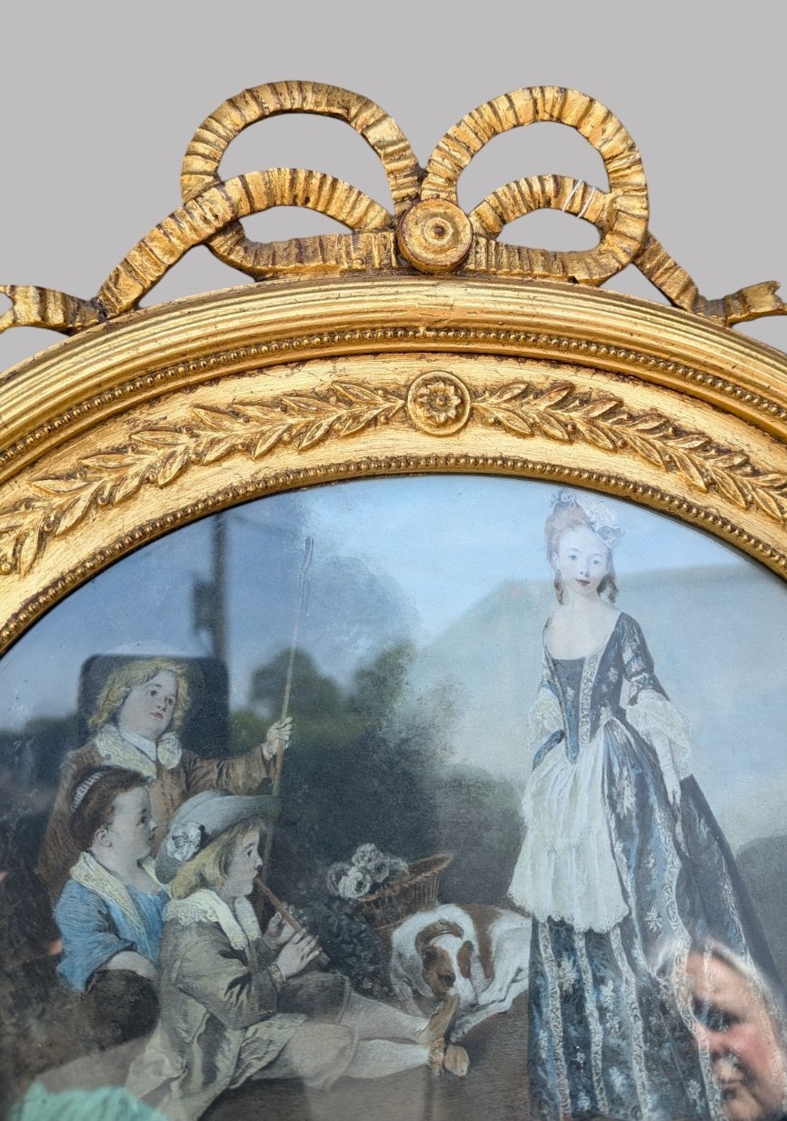 An arched giltwood pier mirror featuring a ribbon bow crest and an upper oval painted scene framed by laurel wreaths above a glass plate. View XI