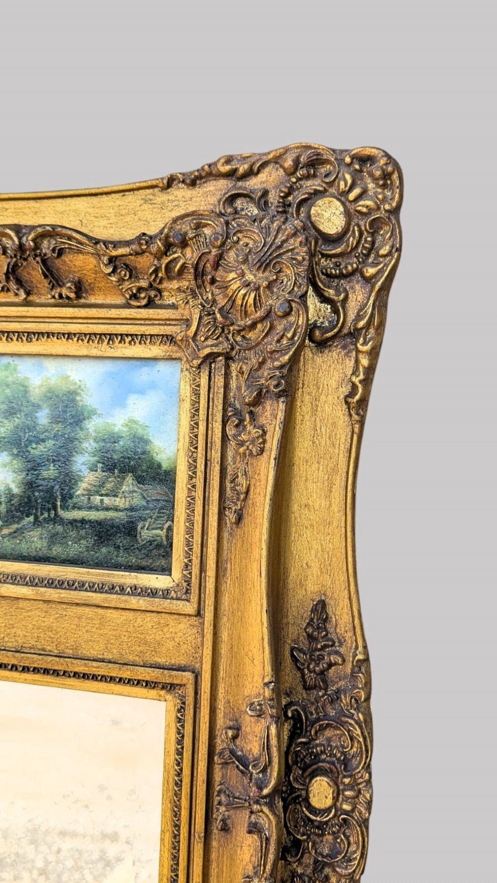 An elongated vertical giltwood pier mirror featuring an upper painted landscape panel above a rectangular glass mirror, set within a carved rococo-style frame. View VI