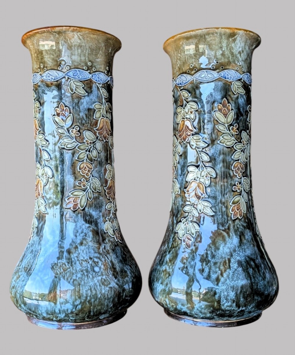 A matching pair of Art Nouveau stoneware vases featuring flared bases, mottled blue and brown glazes, and stylised floral relief decoration. View V