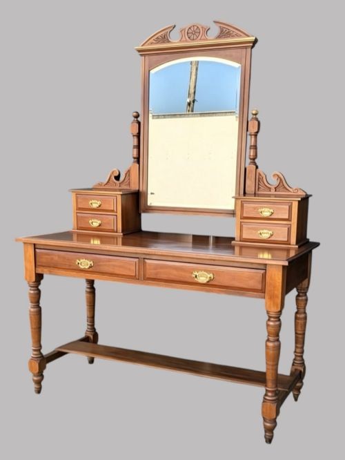 An Edwardian walnut dressing table with an upright swivelling mirror, carved pediment cresting, four drawers, turned legs, and brass hardware. View III