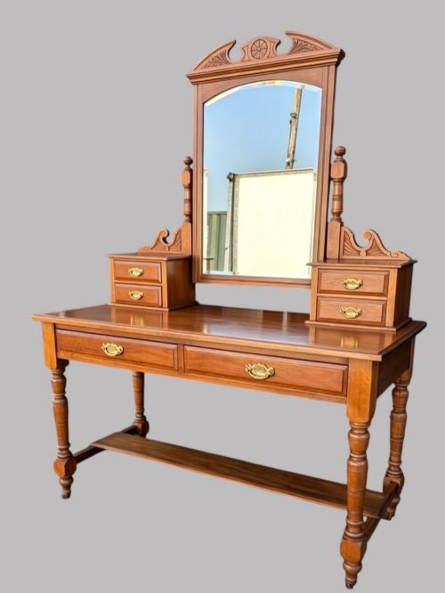 An Edwardian walnut dressing table with an upright swivelling mirror, carved pediment cresting, four drawers, turned legs, and brass hardware. View IV
