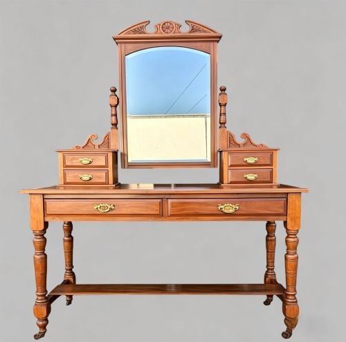 An Edwardian walnut dressing table with an upright swivelling mirror, carved pediment cresting, four drawers, turned legs, and brass hardware. View VII