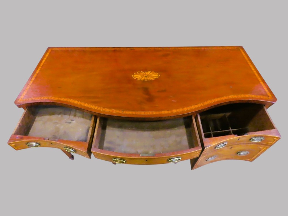 A Georgian serpentine-fronted mahogany sideboard with delicate boxwood inlay, brass drop handles, and square tapered legs. View II