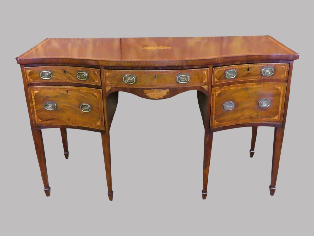 A Georgian serpentine-fronted mahogany sideboard with delicate boxwood inlay, brass drop handles, and square tapered legs. View III