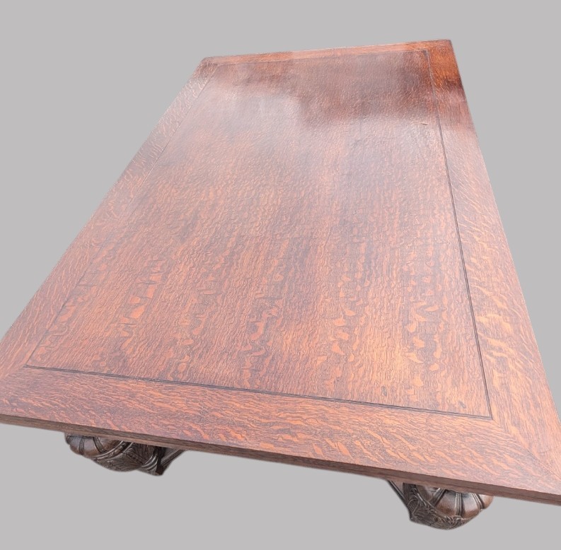 A rectangular extending oak dining table showing a quarter-sawn timber surface and carved bulbous legs underneath. View VIII