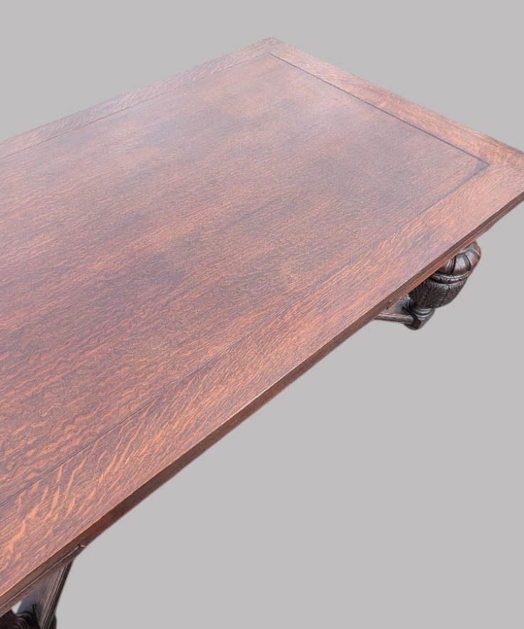 A rectangular extending oak dining table showing a quarter-sawn timber surface and carved bulbous legs underneath. View XI