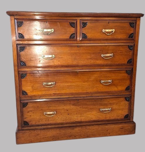 A Victorian mahogany chest of drawers featuring two short drawers over three long drawers with brass drop handles and carved spandrel details on a plinth base. View II