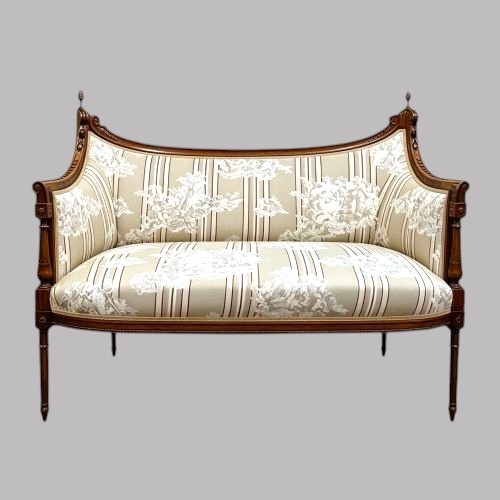 An Edwardian walnut drawing room sofa featuring a sweeping curved backrest, turned front supports, slender tapered legs, and cream striped patterned upholstery. View VIII
