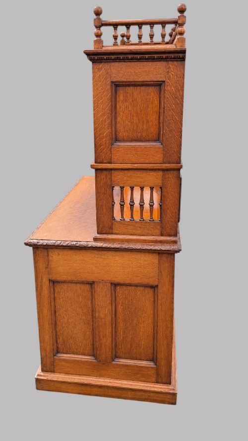 A late Victorian carved oak kneehole desk featuring an upper gallery with drawers, spindles, carved doors, and a pedestal base. View II