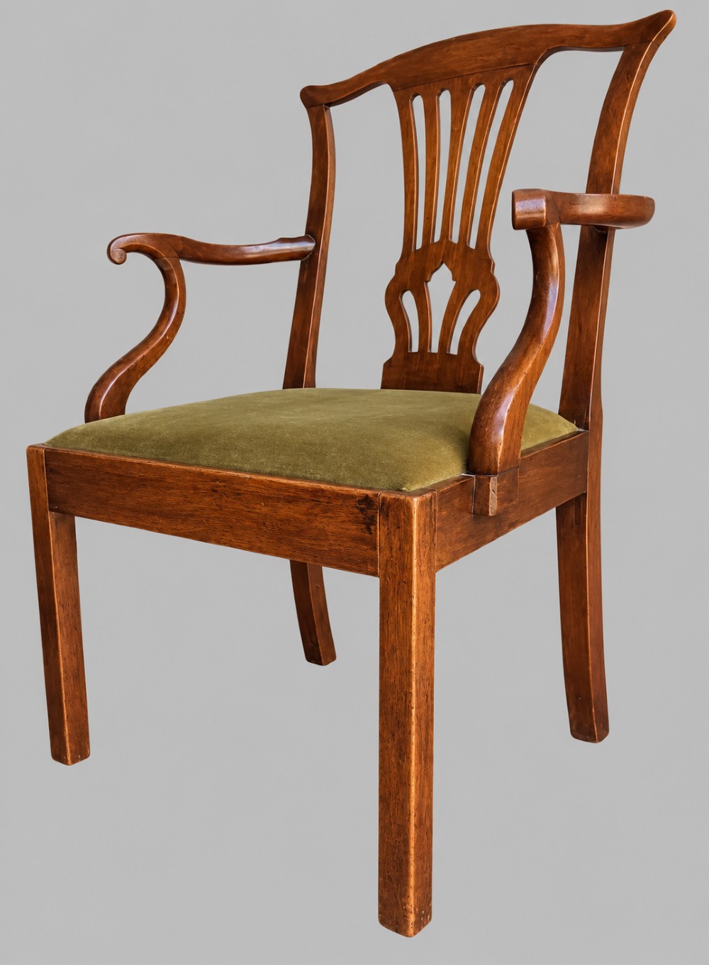 A Georgian Chippendale style mahogany elbow chair with a pierced splat back, shaped arms, and a green velvet seat. View IV