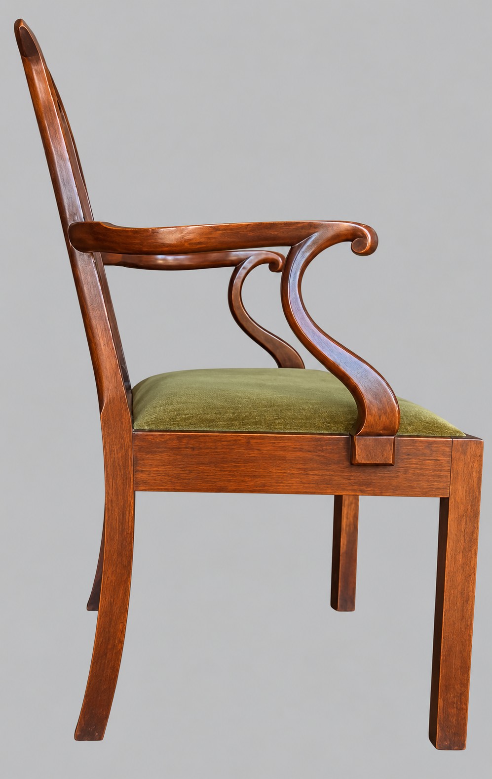 A Georgian Chippendale style mahogany elbow chair with a pierced splat back, shaped arms, and a green velvet seat. View VI