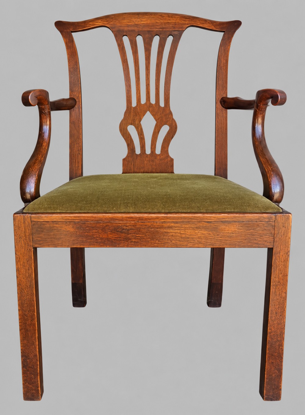 A Georgian Chippendale style mahogany elbow chair with a pierced splat back, shaped arms, and a green velvet seat. View VII