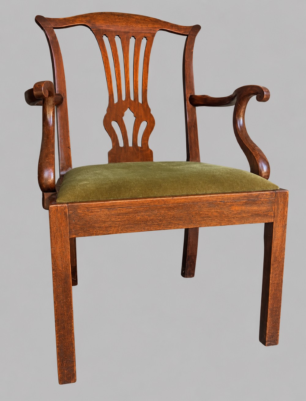 A Georgian Chippendale style mahogany elbow chair with a pierced splat back, shaped arms, and a green velvet seat. View VIII
