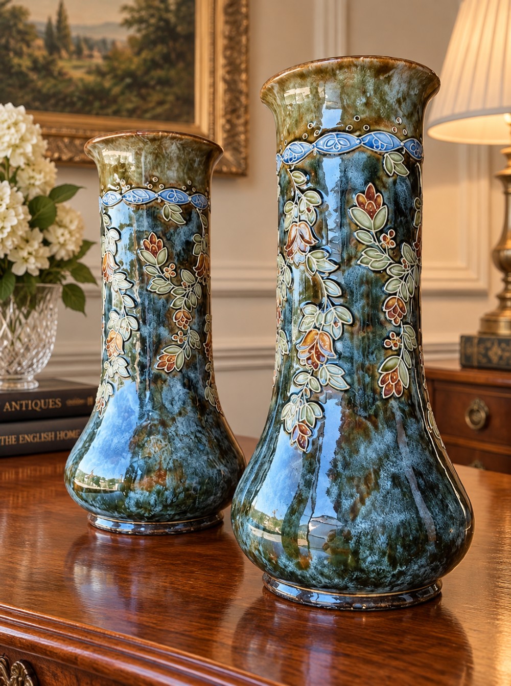 A pair of tall Art Nouveau stoneware vases featuring mottled teal and brown glazes with raised floral and leaf decoration. View IV