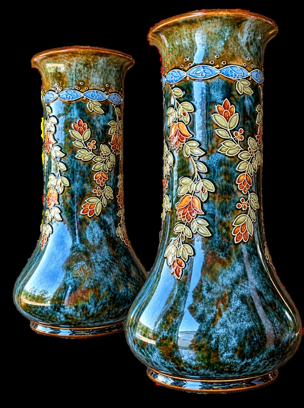 A pair of tall Art Nouveau stoneware vases featuring mottled teal and brown glazes with raised floral and leaf decoration. View II
