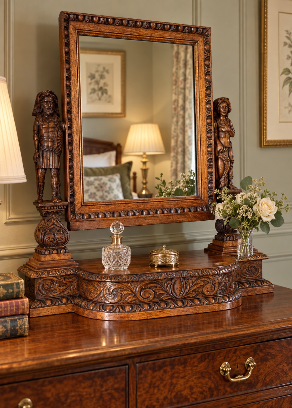 A carved oak dressing mirror featuring a rectangular frame flanked by two carved human figures resting on an ornate plinth base. View II