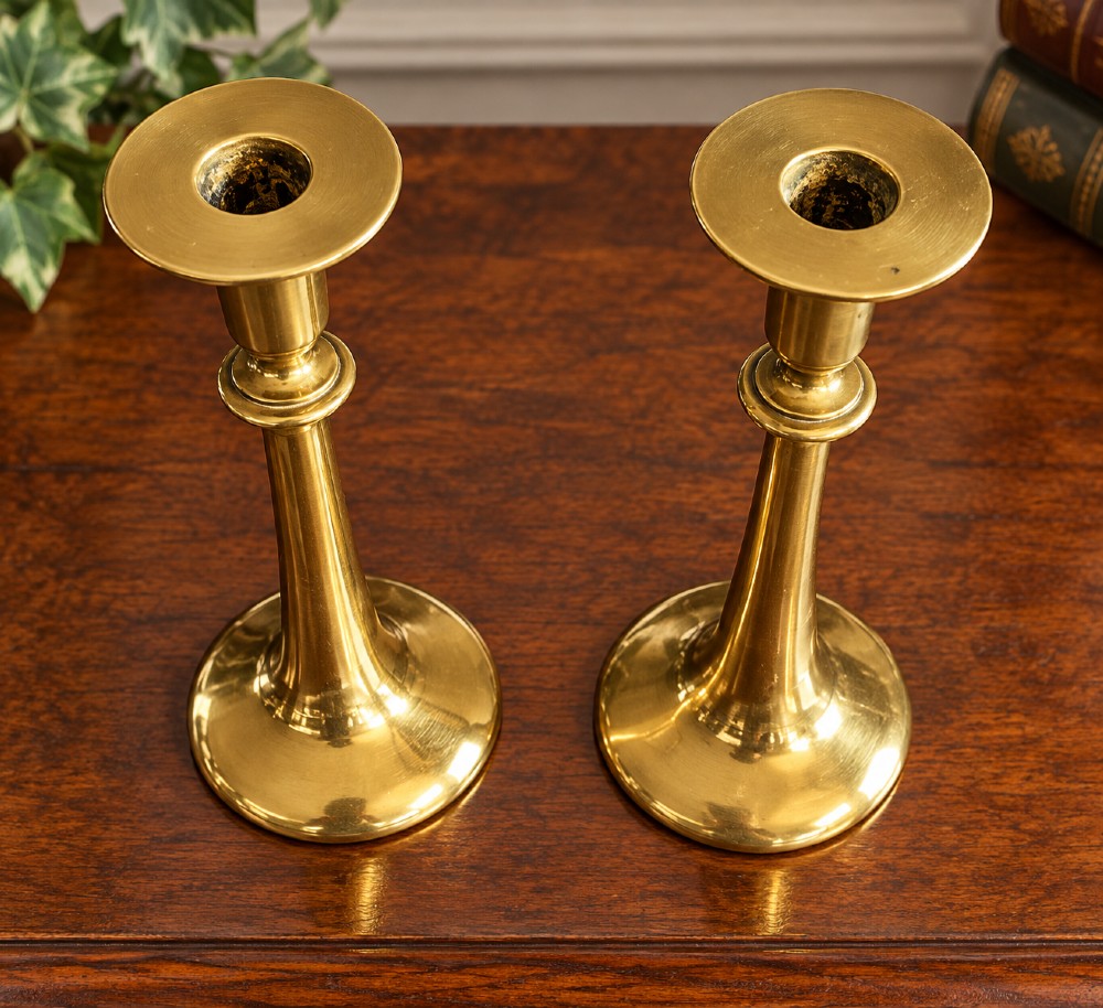 A pair of polished brass Art Nouveau candlesticks featuring tall flared stems and wide circular bases. View II