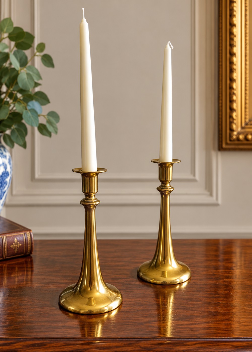 A pair of polished brass Art Nouveau candlesticks featuring tall flared stems and wide circular bases. View V