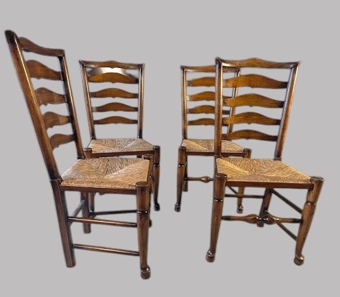 A set of eight dark wood ladderback dining chairs with hand-woven rush seats, including two armchairs and six side chairs. View IV
