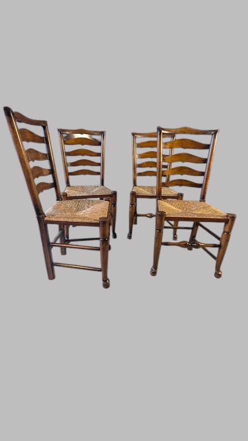 A set of eight dark wood ladderback dining chairs with hand-woven rush seats, including two armchairs and six side chairs. View VIII