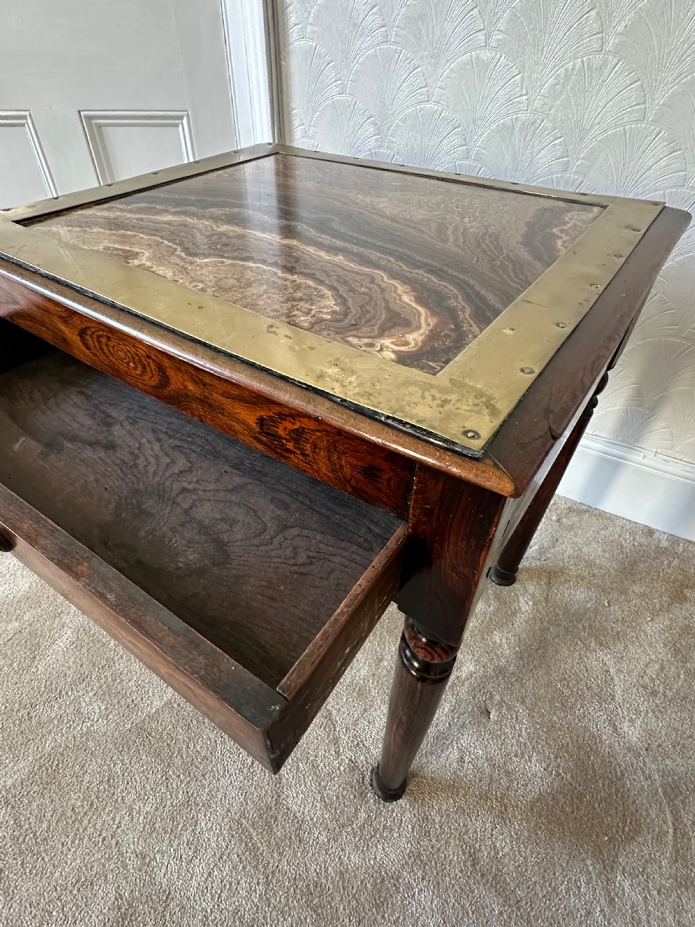 A dark brown Victorian wooden side table with turned legs, a single drawer, and an inset brown marble top with a brass frame. View III